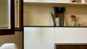 A room with a bed, a white cabinet, and a painting on the wall. - Bnbook - La Corte di Gallarate (Gallarate)