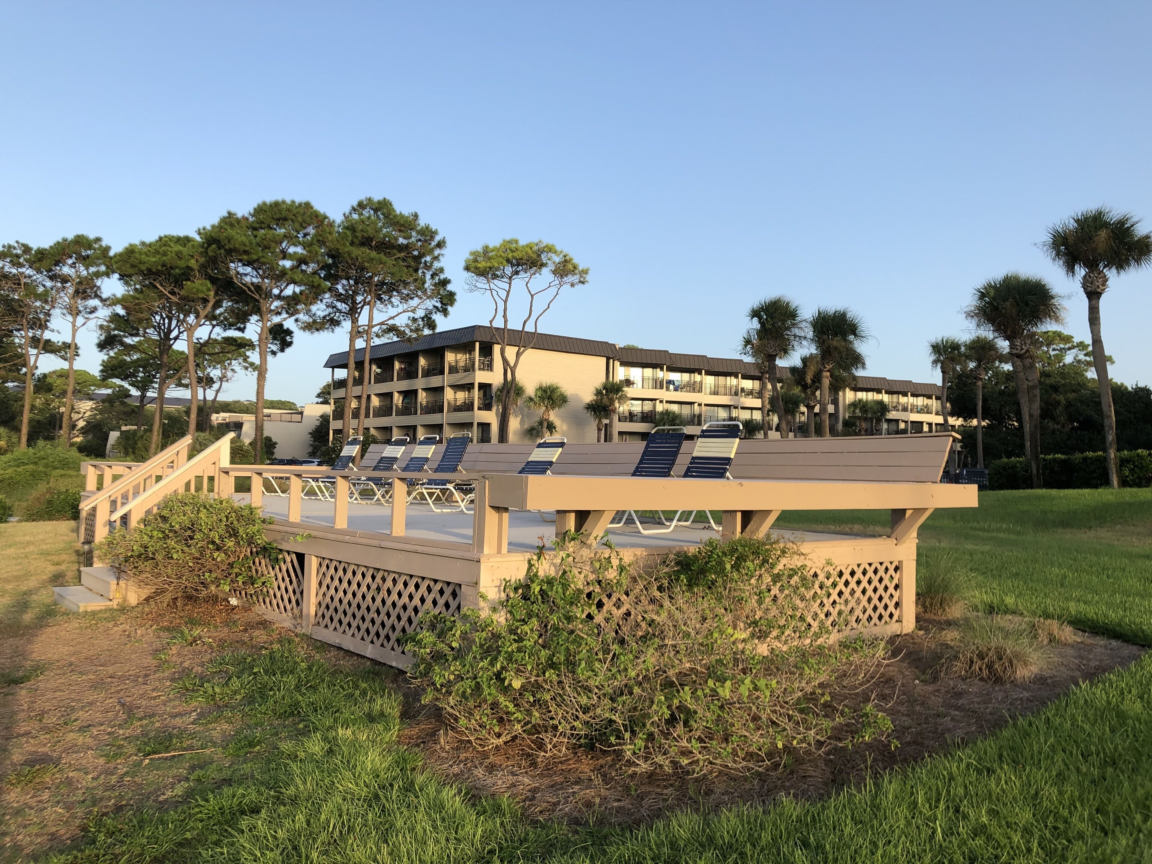 Een resort met een zwembad, ligbedden en een gebouw met meerdere balkons.