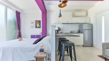 Ein modernes Schlafzimmer mit Bett, Nachttisch und einem Fenster mit Vorhängen.