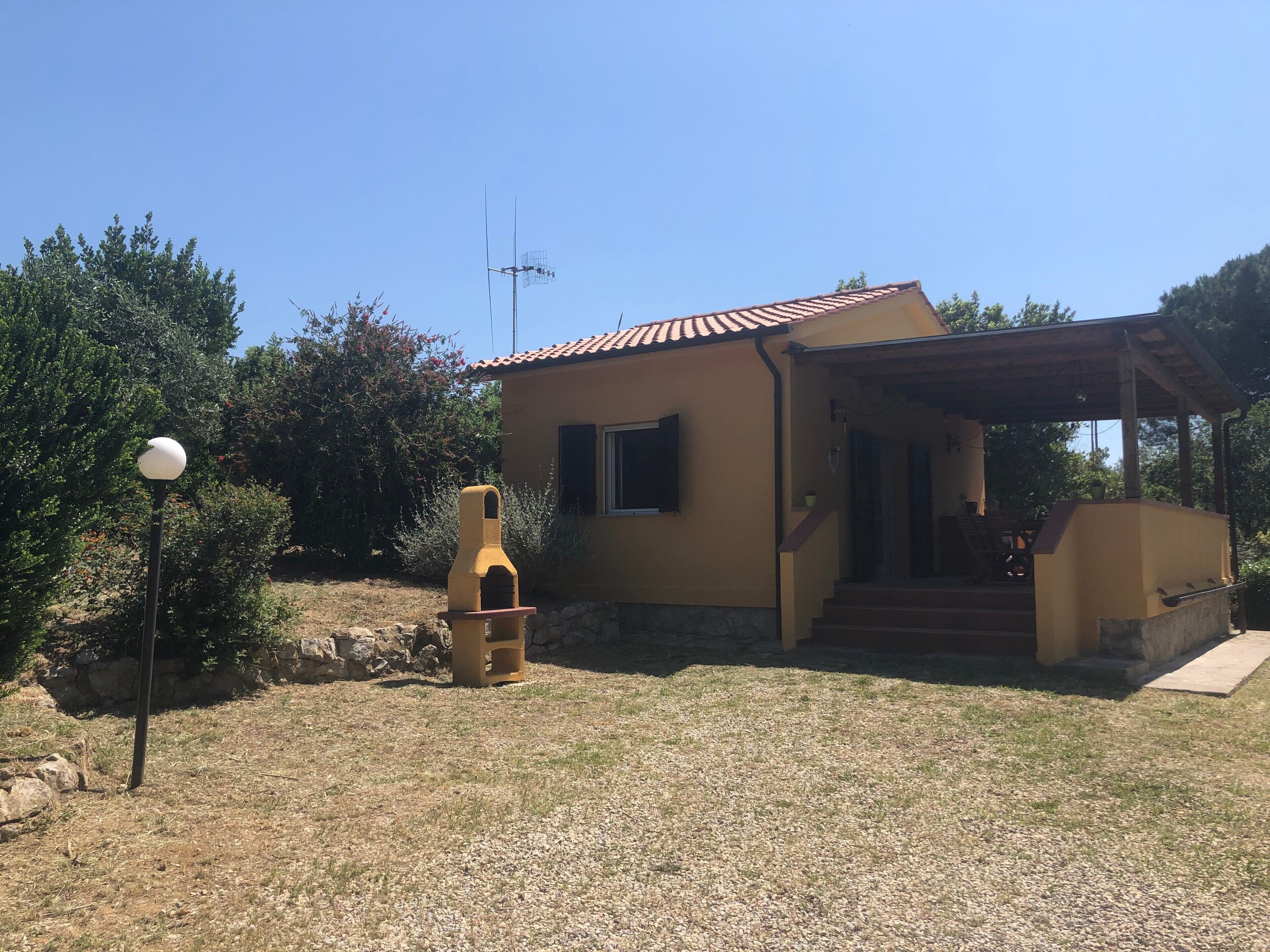 Una casa con tetto in tegole, un camino e un piccolo portico.