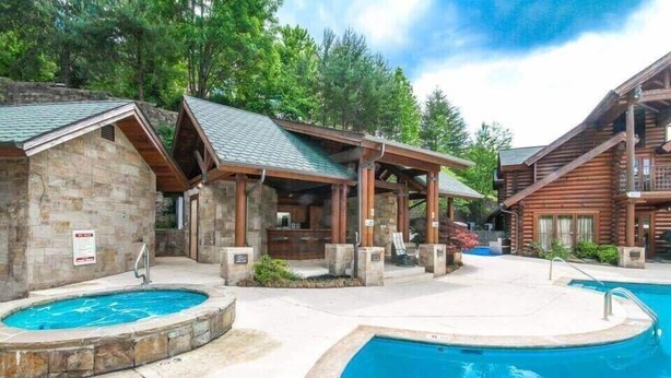 Un área de piscina con dos jacuzzis y cabañas de madera.