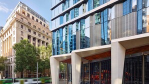 A modern building with large windows and a glass facade, featuring a prominent entrance with a wooden overhang. - W Melbourne (Melbourne)