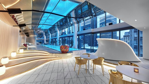 A modern hotel lobby with a curved reception desk, seating area, and a pool. - W Melbourne (Melbourne)
