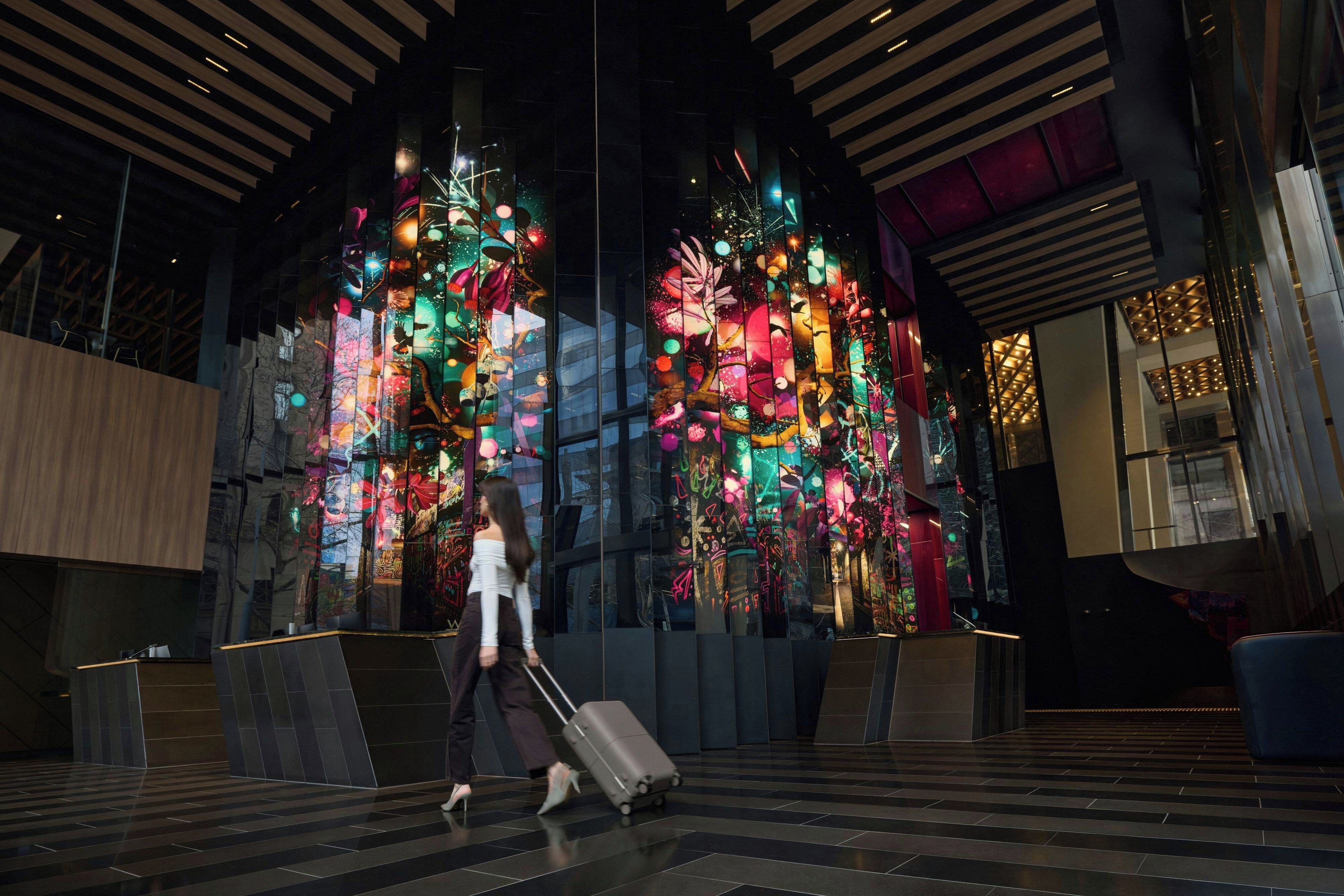 A modern interior with a large digital display featuring colorful abstract art.