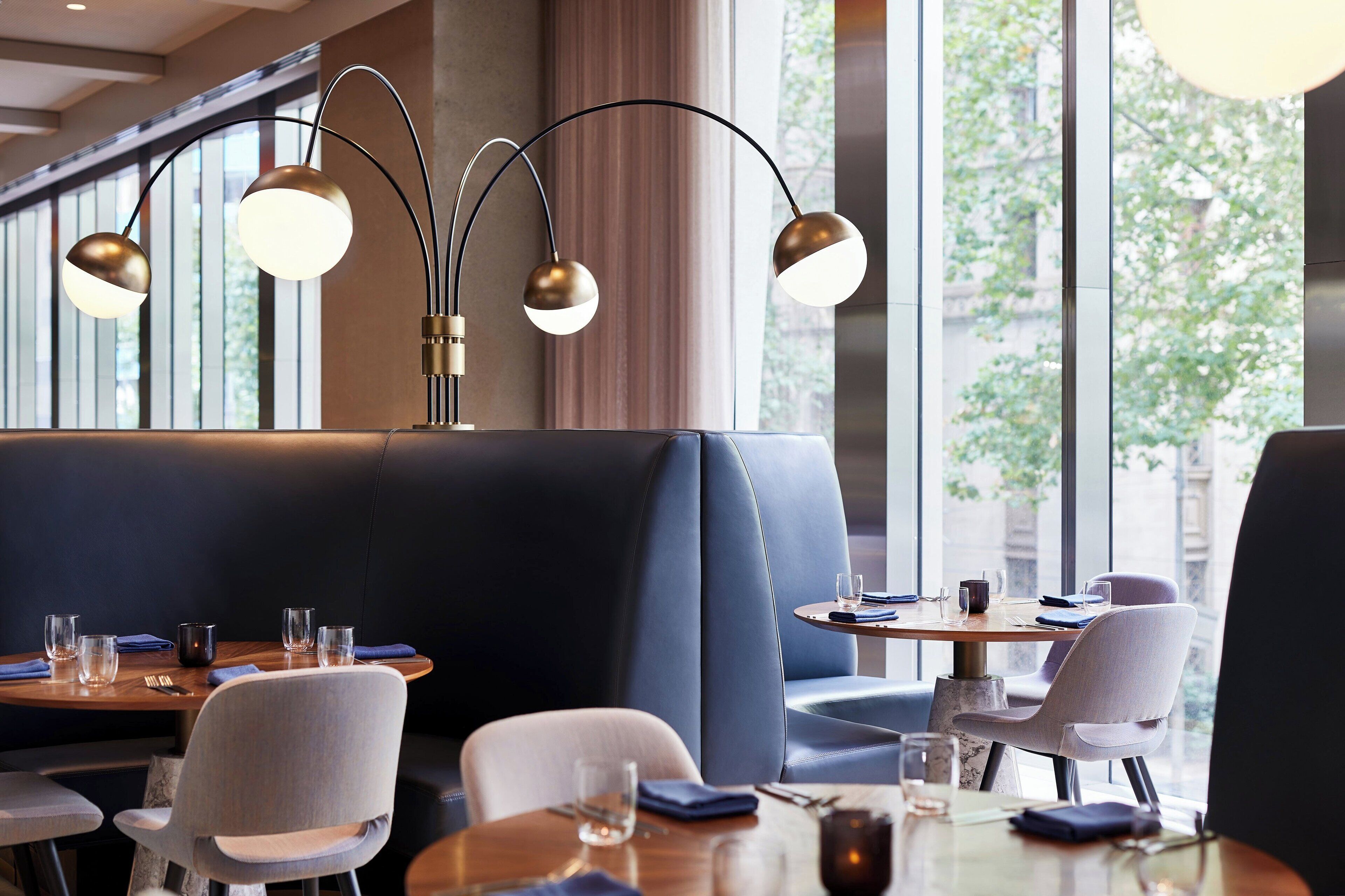 A restaurant with a modern interior, featuring leather booths and a variety of seating options.