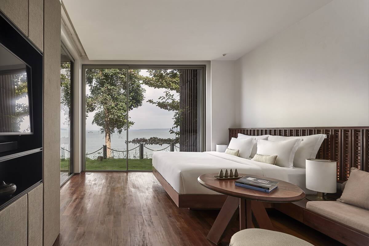 Une chambre d’hôtel moderne avec un grand lit, un canapé, une petite table et un téléviseur.