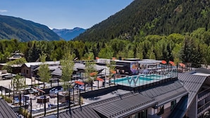 A modern hotel with a rooftop pool, surrounded by forested mountains. - The Sky Residences at W Aspen (Aspen)
