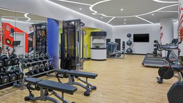 A modern gym with various exercise equipment, including treadmills, weight machines, and kettlebells.