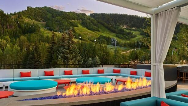 A modern outdoor seating area with a fire feature, overlooking a mountainous landscape. - The Sky Residences at W Aspen (Aspen)