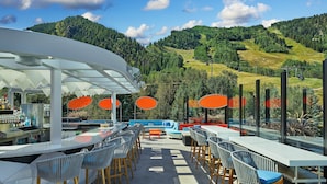 An outdoor bar area with a view of a mountainous landscape. - The Sky Residences at W Aspen (Aspen)