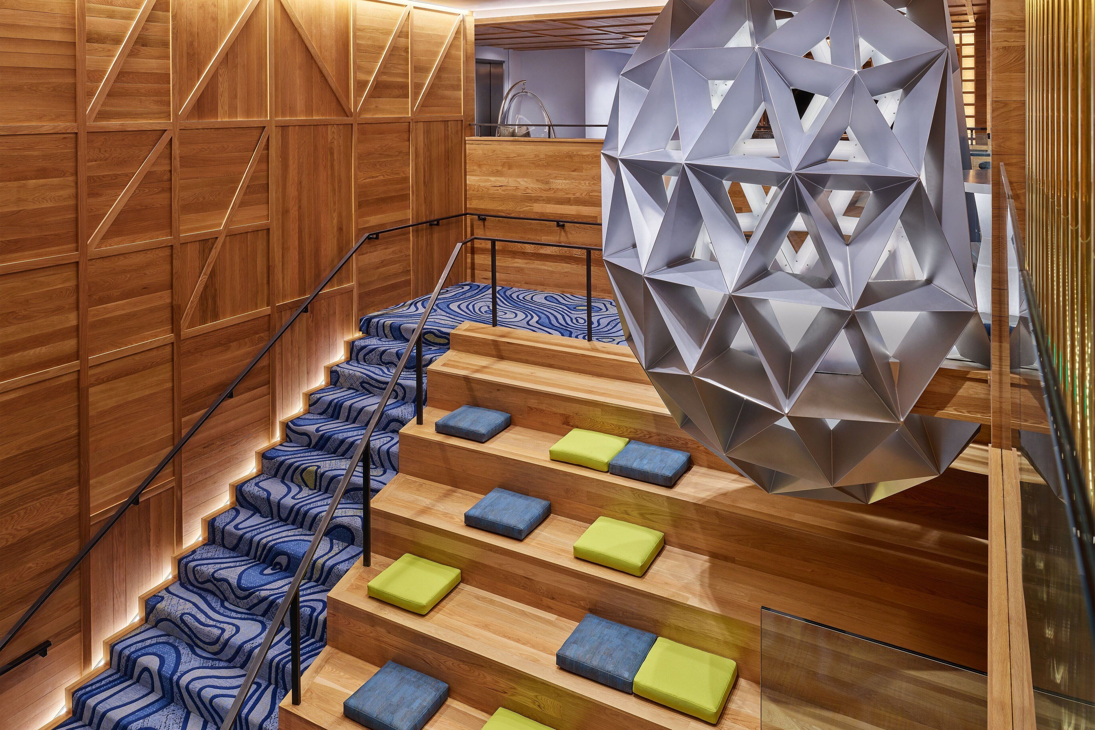A modern staircase with wooden steps and geometric wall panels.