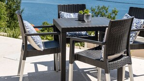 Ein Tisch und vier Stühle mit Blick auf das Meer.