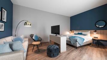 Une chambre moderne avec un lit, un bureau, une chaise et un miroir rond.