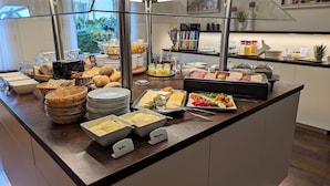A buffet with various food items, including bread, cheese, and fruits. - Medium double room - Altstadthotel Goldene Kugel Object ID 124185 (Waren (Müritz))