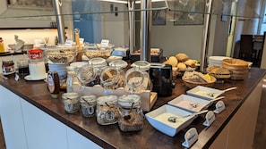 A buffet counter with various food items and condiments.