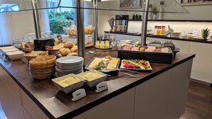 A buffet with various food items, including bread, cheese, and fruits. - Single room Standard - Altstadthotel Goldene Kugel Object ID 124185 (Waren (Müritz))