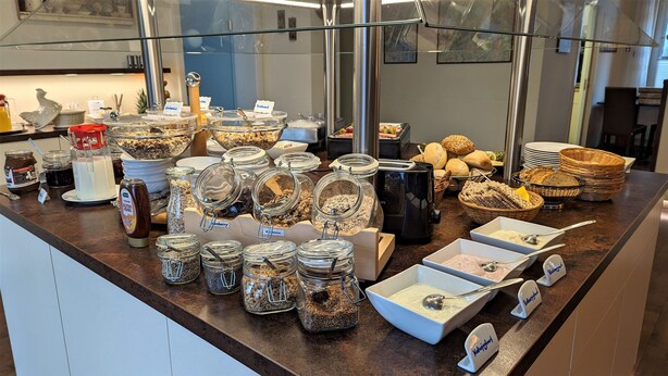 A buffet counter with various food items and condiments. - Single room Standard - Altstadthotel Goldene Kugel Object ID 124185 (Waren (Müritz))