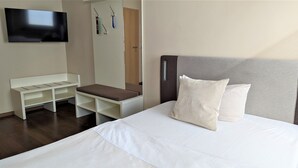 A hotel room with a bed, a TV mounted on the wall, a bench with storage compartments, and a door with a handle. - Single room Standard - Altstadthotel Goldene Kugel Object ID 124185 (Waren (Müritz))