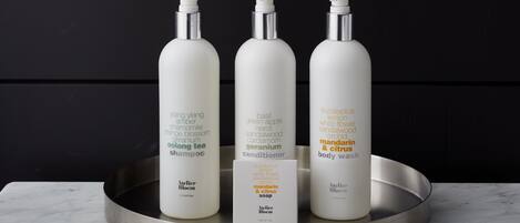 Three bottles of skincare products on a metallic tray against a dark background.