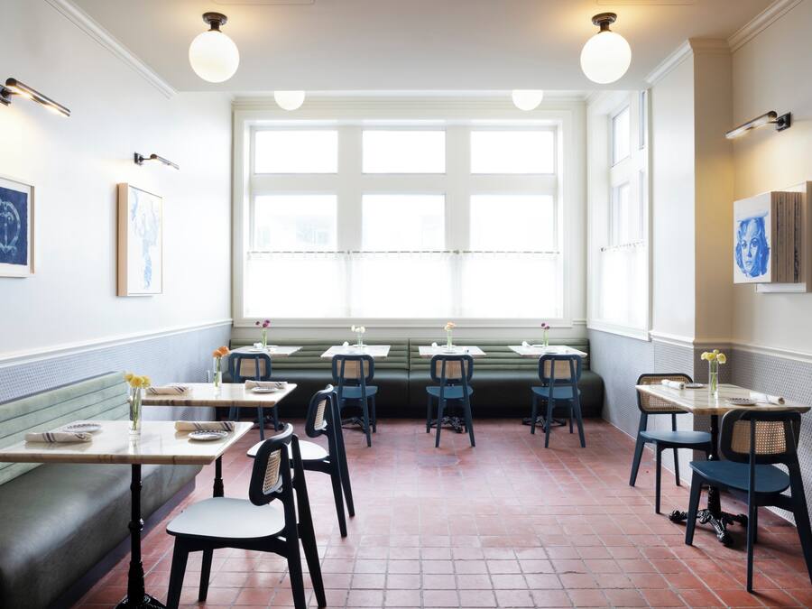 L’intérieur d’un restaurant avec un long comptoir, des banquettes et une grande fenêtre.