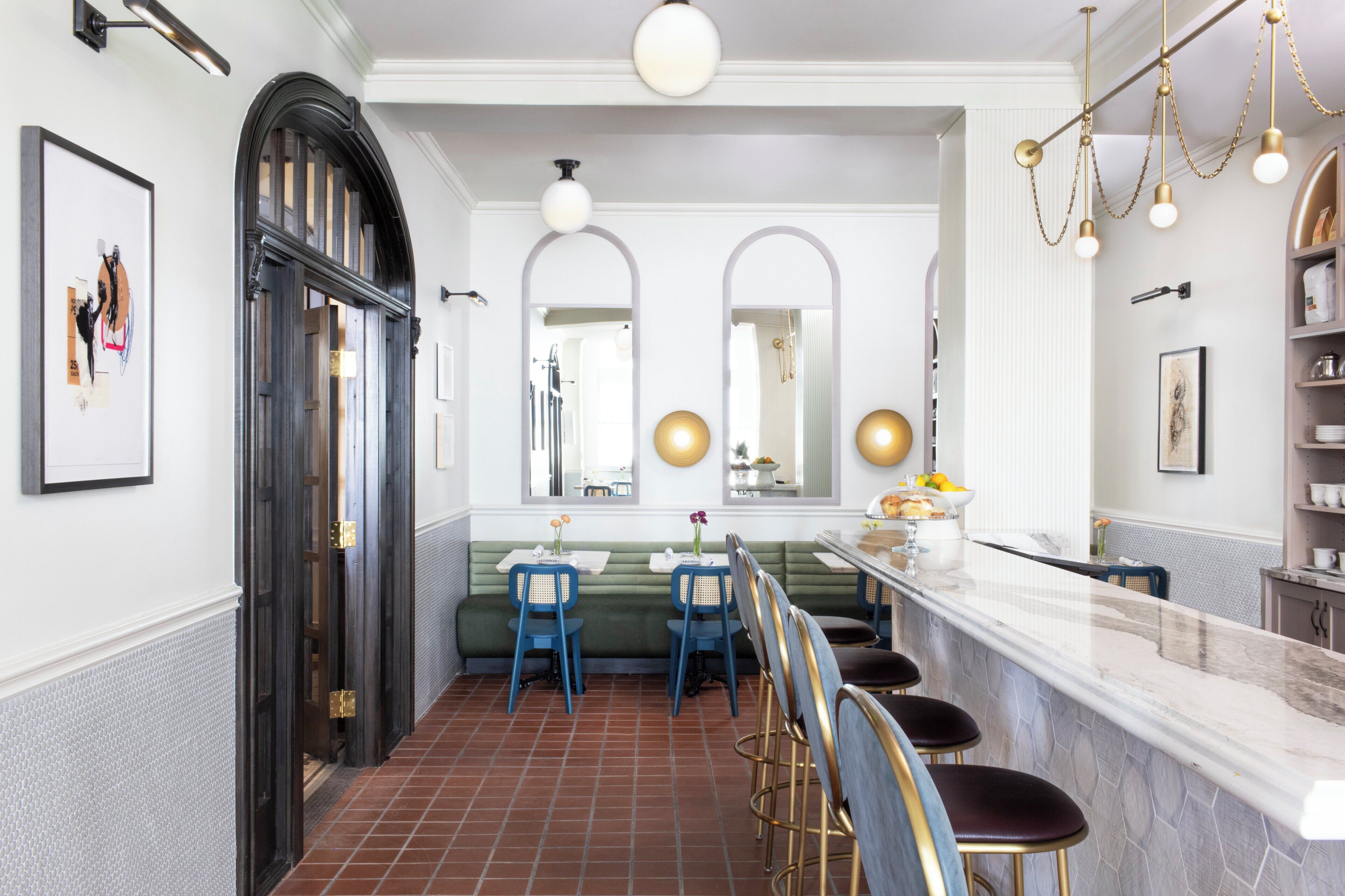 A restaurant interior with a bar area, seating, and decorative mirrors.