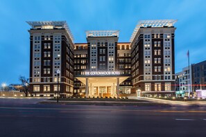 Un hotel con una entrada destacada, varios pisos y un diseño arquitectónico moderno.