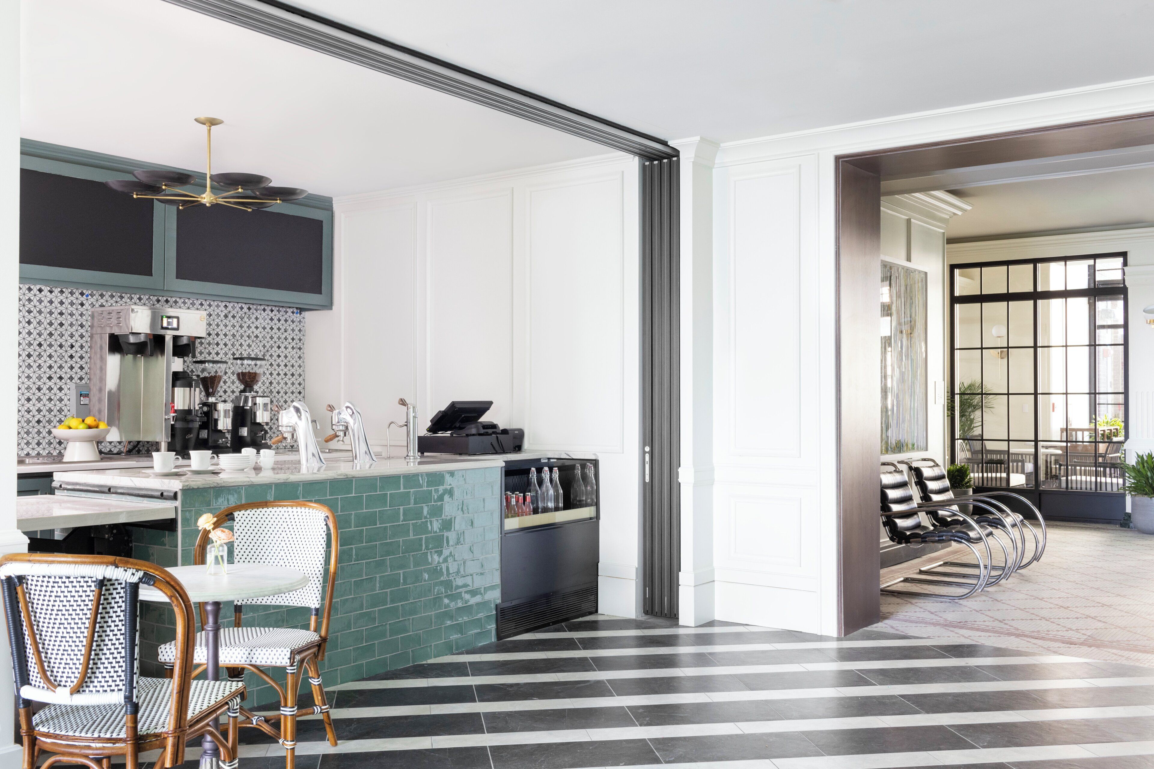 Une cuisine moderne avec un coin bar, un espace repas avec des chaises et une vue sur l’extérieur.