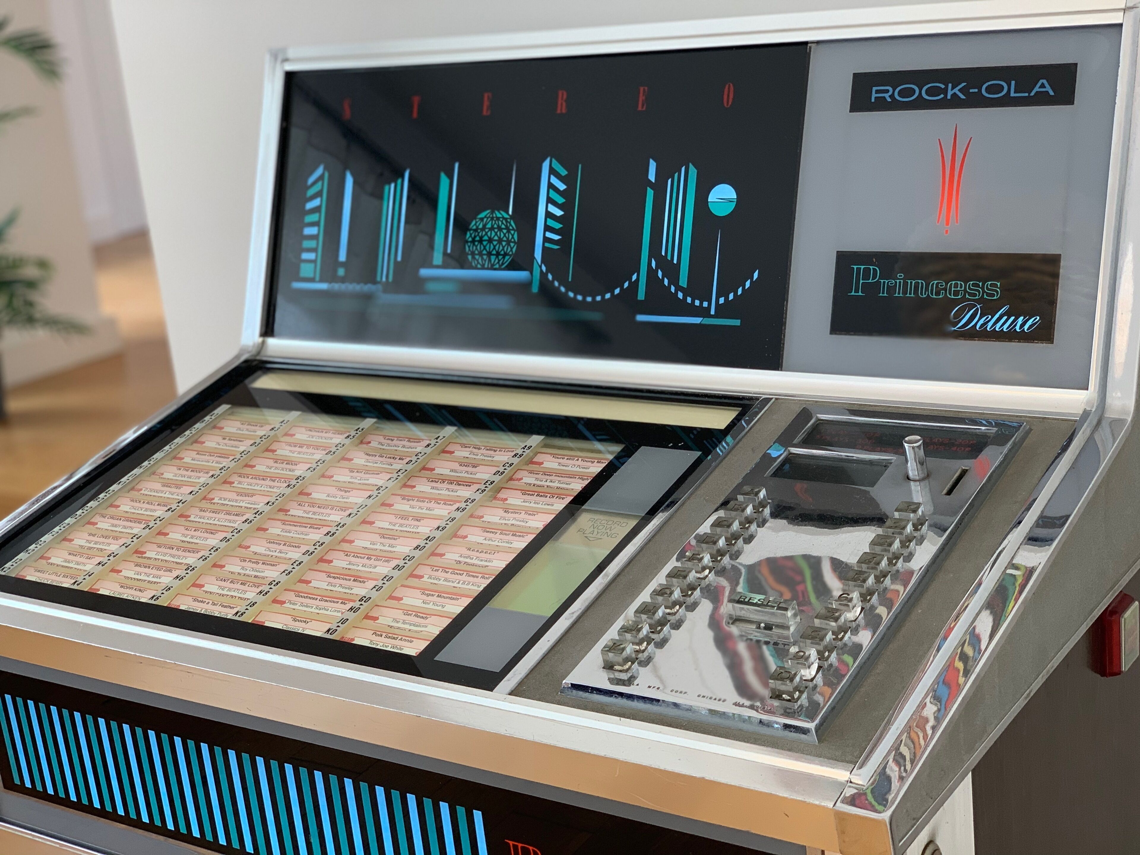 A jukebox with a selection of records and a Rock-Ola logo.