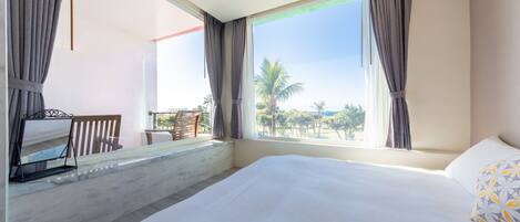 Una habitación de hotel con una cama grande, una mesita y una silla cerca de la ventana.