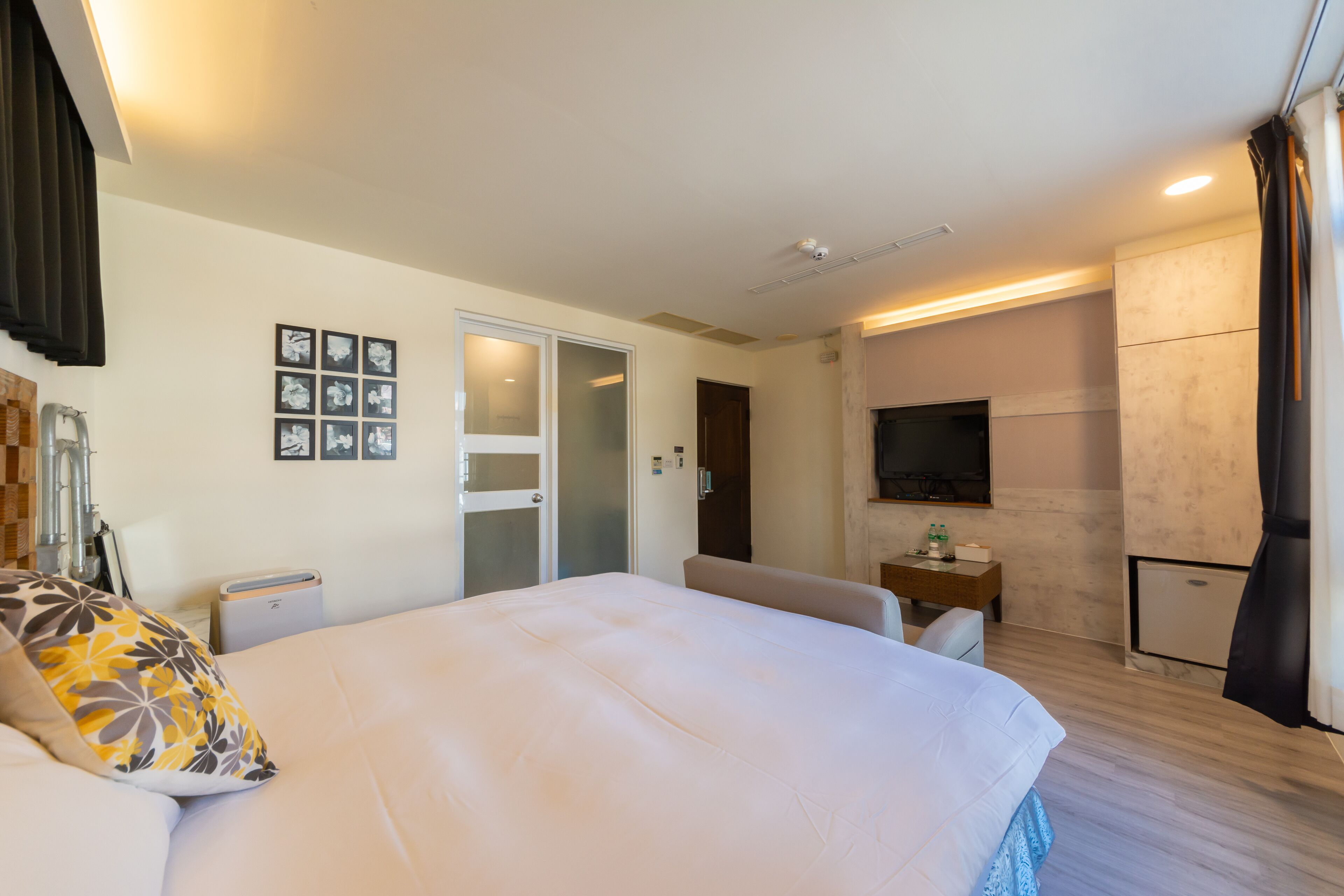 Une chambre d’hôtel moderne dotée d’un grand lit, d’un bureau, d’une télévision à écran plat et d’une porte donnant accès à une salle de bain.