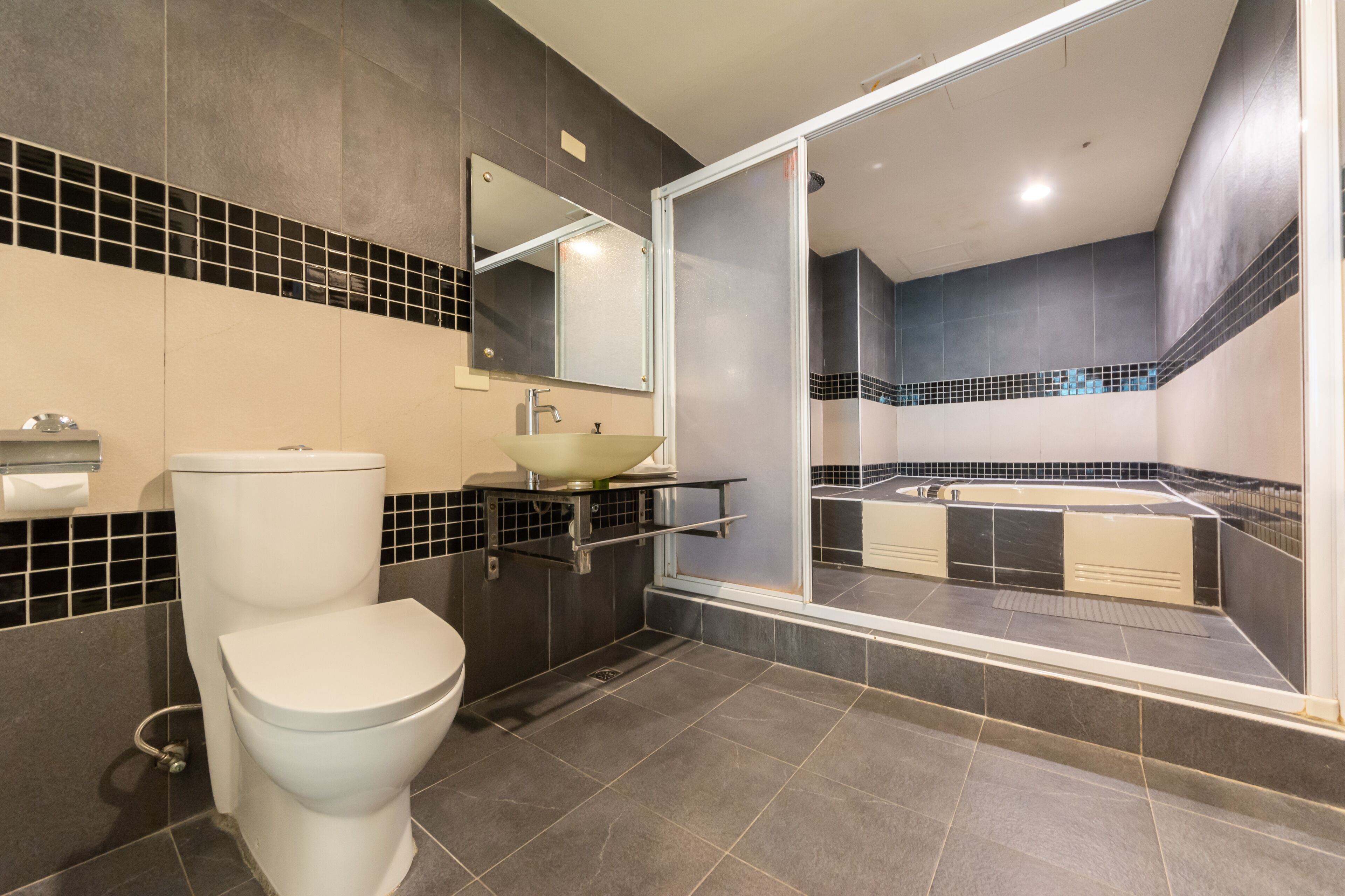 A modern bathroom with a toilet, sink, and bathtub.