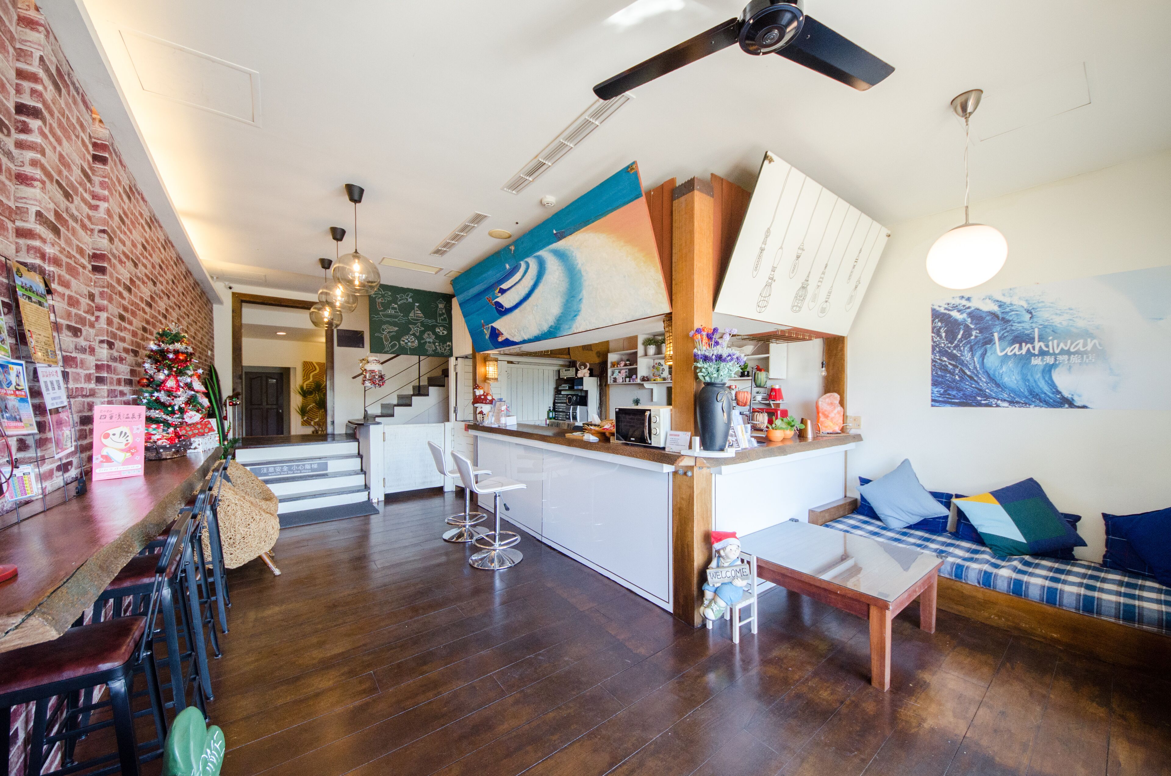 A modern kitchen with a central island, bar seating, and a cozy seating area with a sofa and cushions.