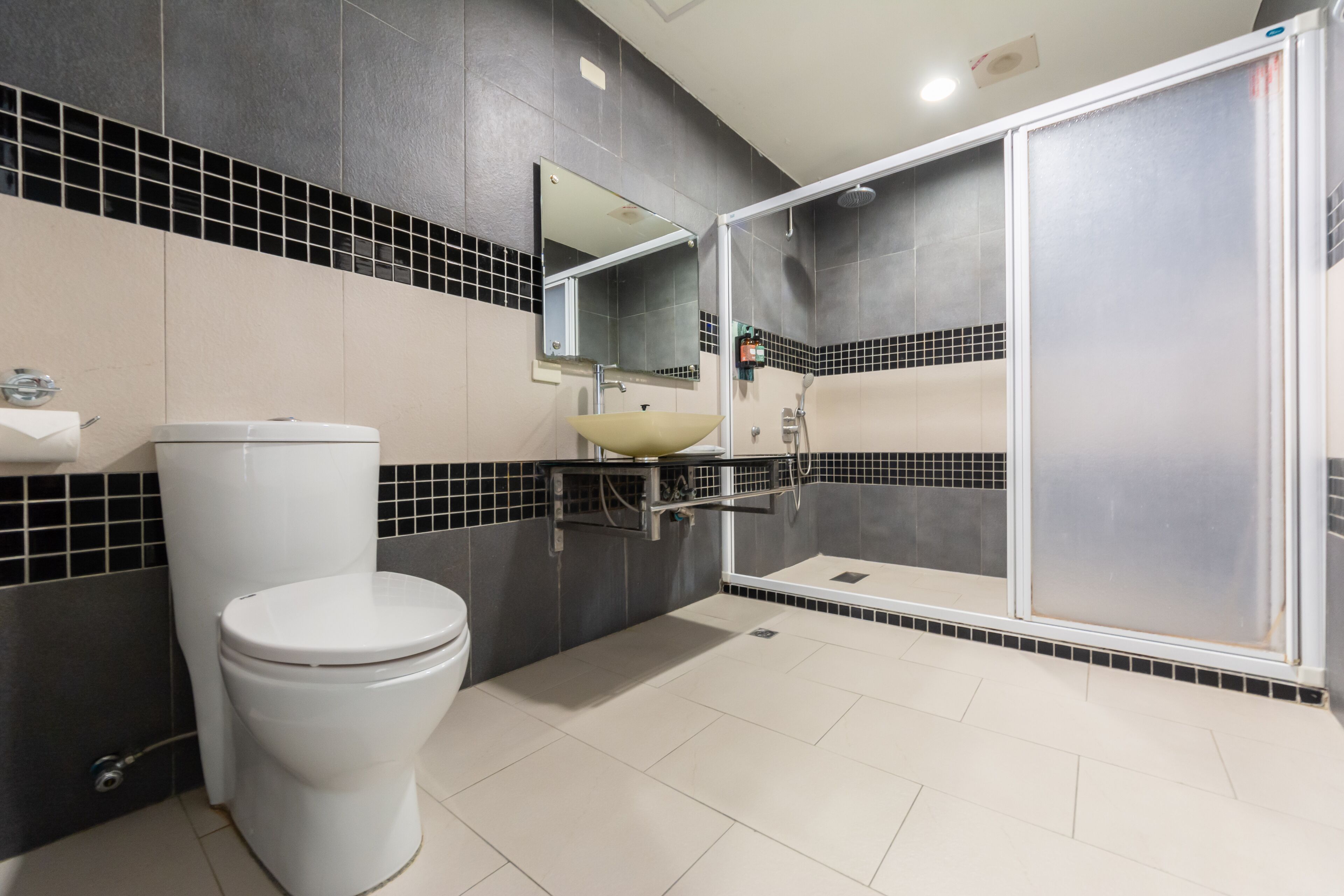 A modern bathroom with a toilet, sink, and shower.