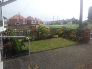 A residential street with houses, a grassy area, and a paved path. - Remarkable 3-bed House in Durham (Durham)