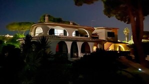 A large, multi-story building with arched windows and a flat roof, surrounded by greenery. - Fronte Mare - Facing the sea (Perd'e Sali)