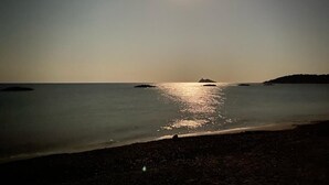 A beach scene at night with a bright moon and calm sea. - Fronte Mare - Facing the sea (Perd'e Sali)