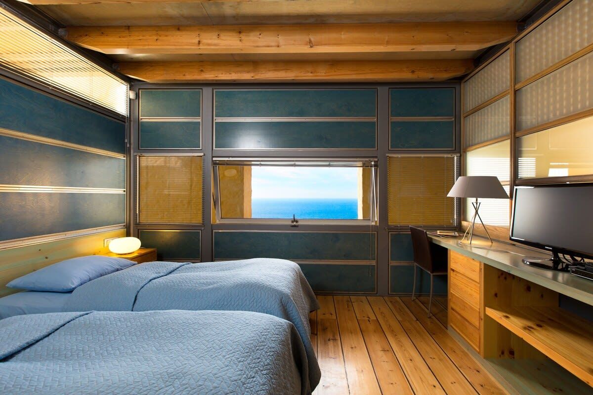 Una habitación con cama, escritorio y ventana con vistas.