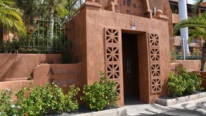 Un edificio con un diseño arquitectónico único, que presenta una entrada abovedada grande y detalles decorativos tallados.