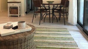 Un comedor moderno con una mesa redonda, cuatro sillas y un adorno en la pared que deletrea 'HHI'.