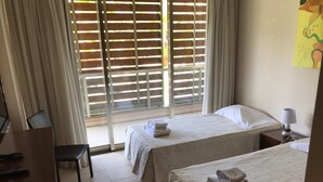 Ein Hotelzimmer mit zwei Betten, einem Schreibtisch und einem Stuhl.