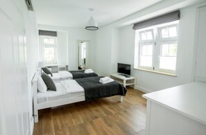 A modern, well-lit room with two beds, a TV, and a desk. - Apartamenty Stella Mare - 365 PAM (Ustronie Morskie)