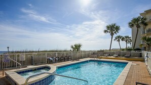 A swimming pool with a hot tub, lounge chairs, and palm trees. - Gulf-front corner unit. 5th floor. Beach service during season! (Fort Walton Beach)