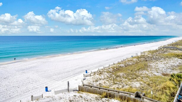 A beach with a wooden boardwalk, sandy dunes, and a clear blue sky. - Gulf-front corner unit. 5th floor. Beach service during season! (Fort Walton Beach)