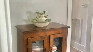 A wooden cabinet with glass doors containing various items.