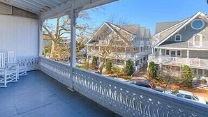 A covered porch with a view of houses and trees. - Completely Renovated Victorian across from Congress Hall (Cape May)
