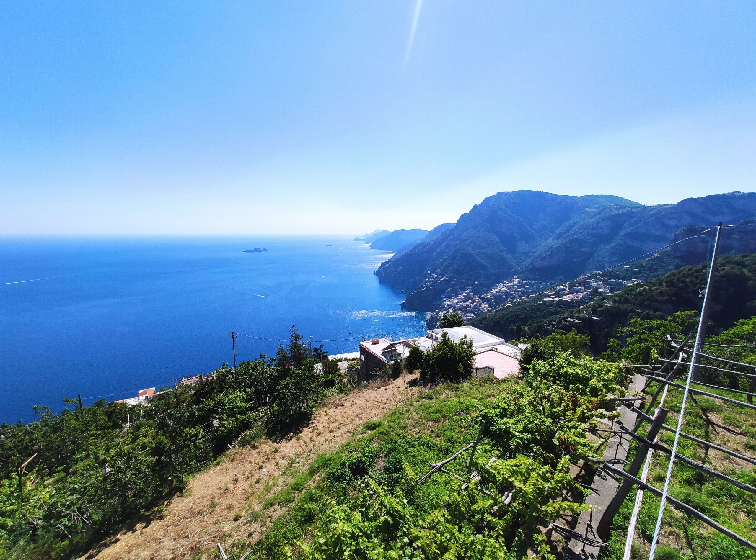 Eine Küstenlandschaft mit Weinbergen, einer kleinen Stadt und Blick aufs Meer.