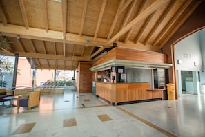 A spacious lobby with a wooden reception desk and seating area. - Caybeach Meloneras (San Bartolomé de Tirajana)