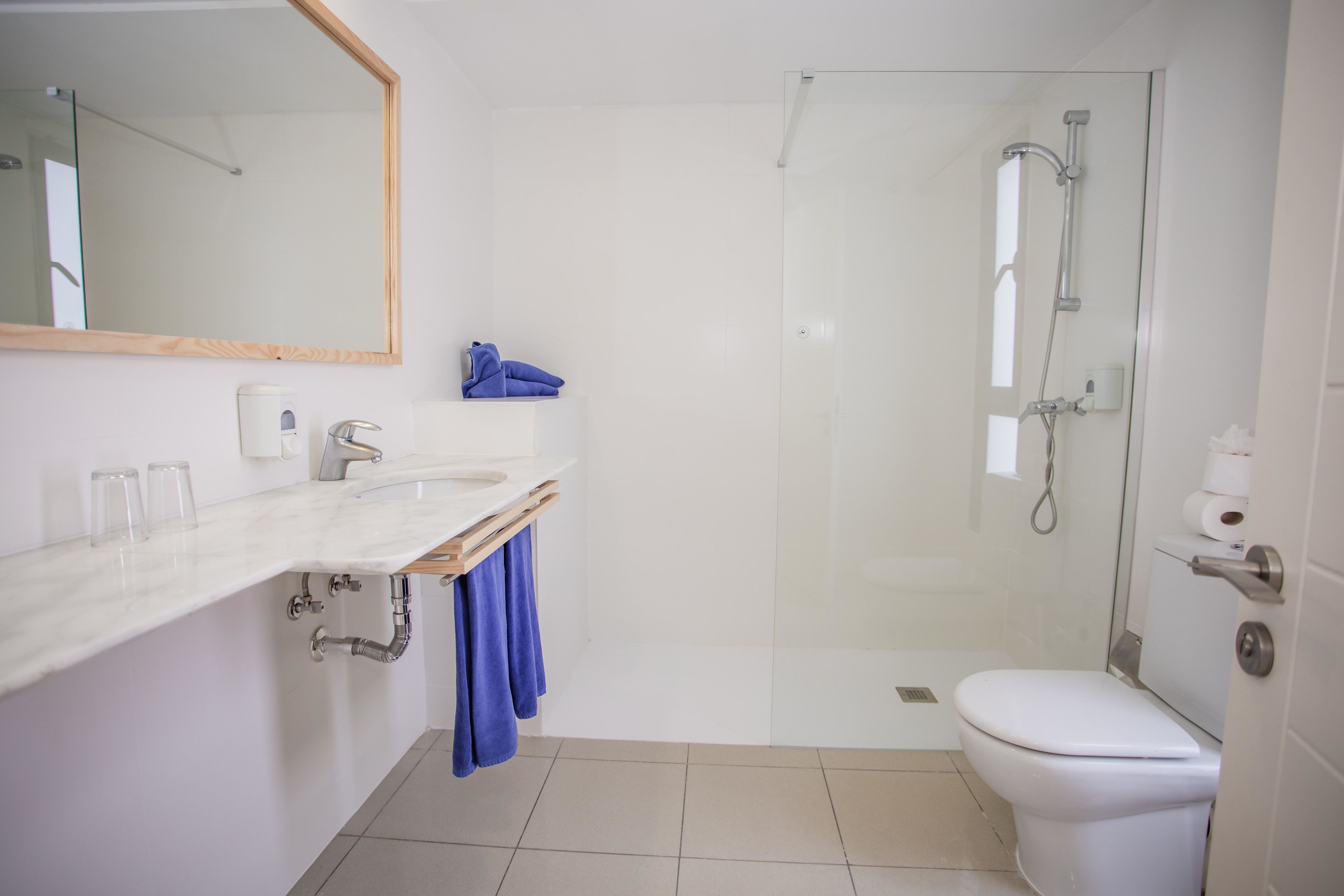 Une salle de bain moderne avec un lavabo blanc, un miroir et des toilettes.