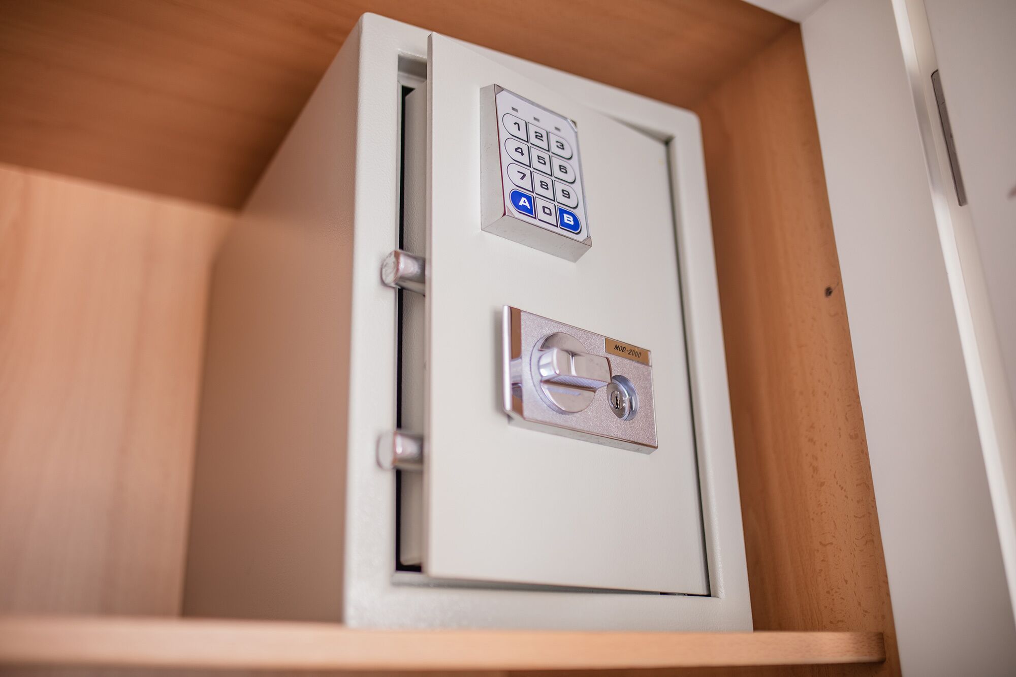 A metal safe with a keypad and a combination lock.