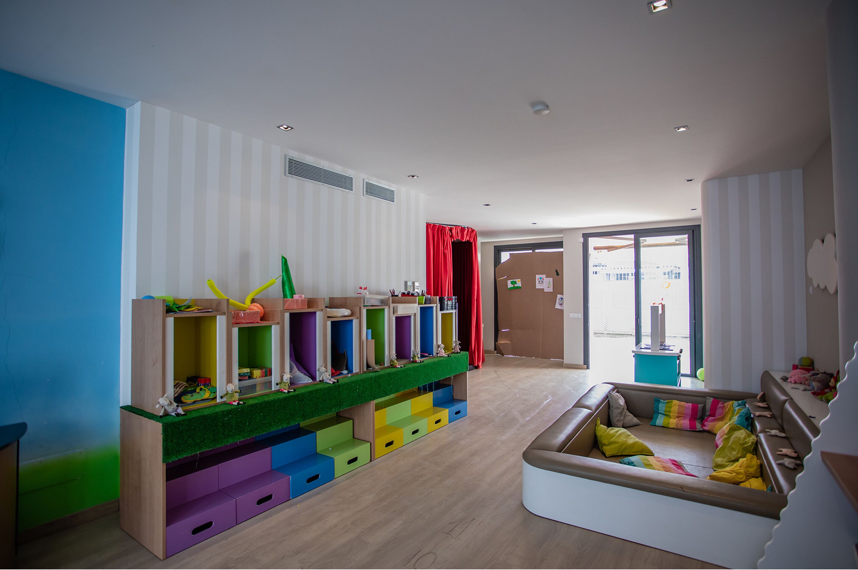 A children's play area with colorful storage units and a cushioned seating area.